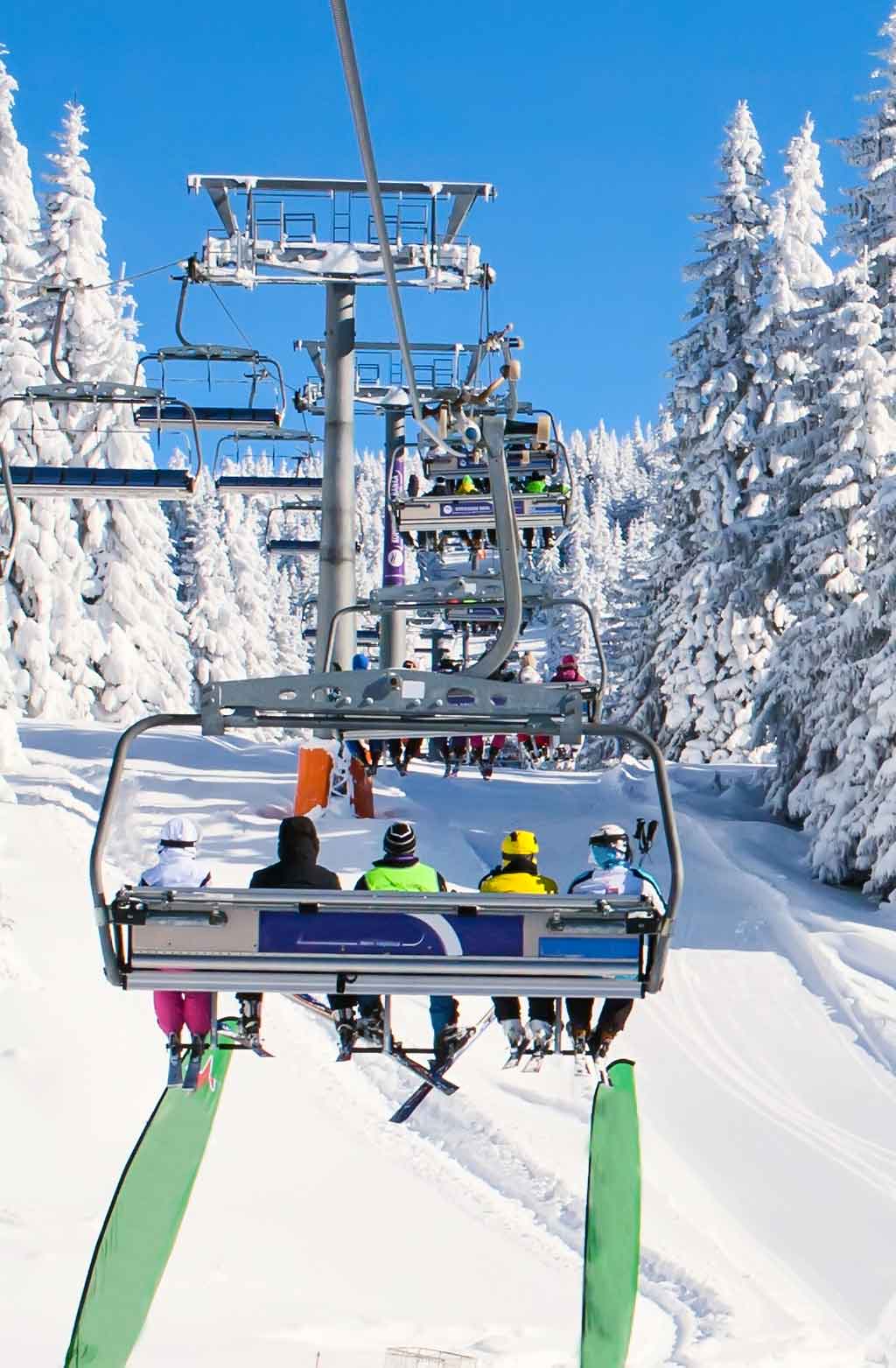 Skiers on the Fai della Paganella ski lifts in Trentino