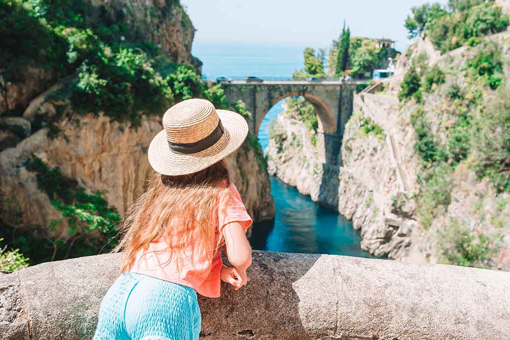Turista guarda la spiaggia di cala di Furore