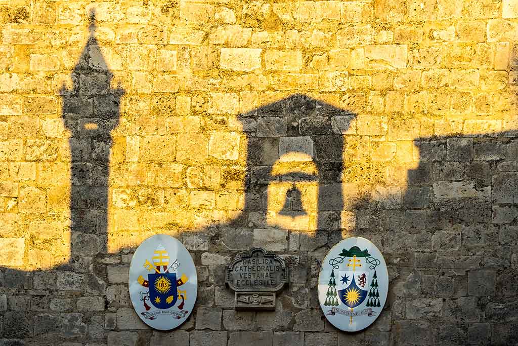 Vieste, ombre del campanile che riflette su muro di pietra